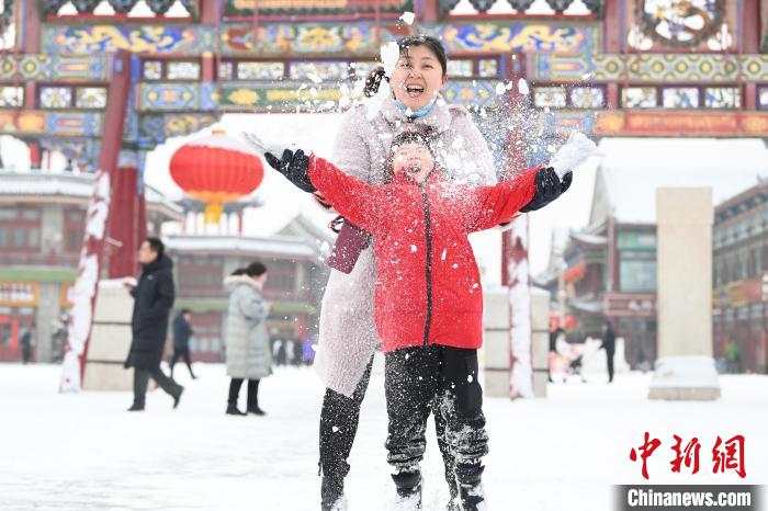 2月13日，家長(zhǎng)與小朋友在呼和浩特市大召?gòu)V場(chǎng)享雪趣。　劉文華 攝