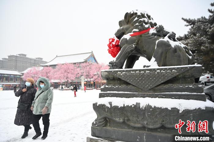 2月13日，民眾在呼和浩特市大召?gòu)V場(chǎng)雪中漫步?！⑽娜A 攝