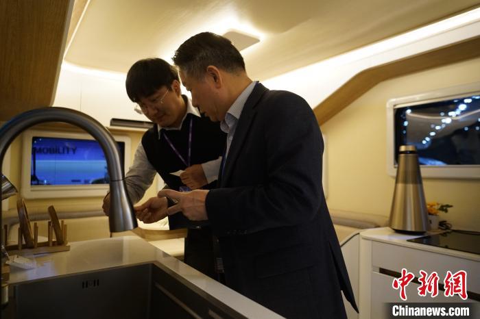 圖為參展商向觀眾介紹房車內(nèi)部設(shè)計(jì)?！⑿?攝