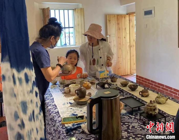 圖為：游客正在咨詢臺(tái)灣柴燒作品?！∪~秋云 攝