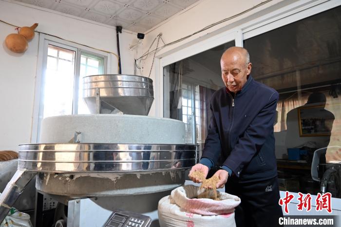 李家莊村民谷文朝重拾父輩的手藝，做起石磨面粉的營生?！〉杂鸺?攝