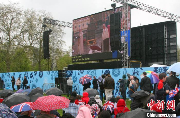 當(dāng)?shù)貢r(shí)間5月6日，英國國王查爾斯三世的加冕儀式舉行。民眾雨中觀看儀式。　歐陽開宇 攝