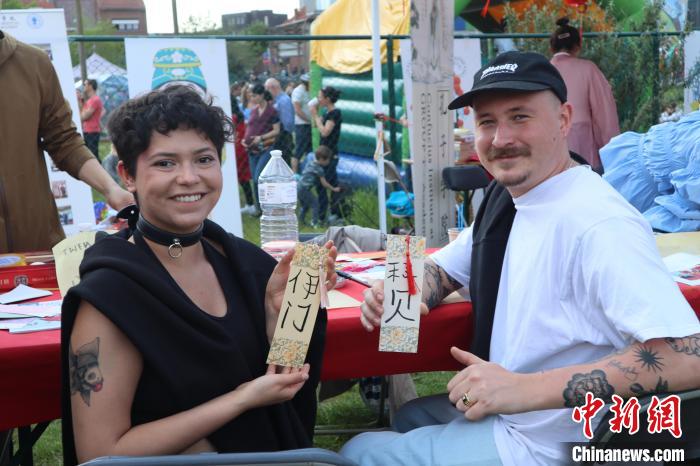 當地民眾在漢字體驗工作坊展示自己手寫的中文名書簽?！◆斻肟鬃訉W院供圖