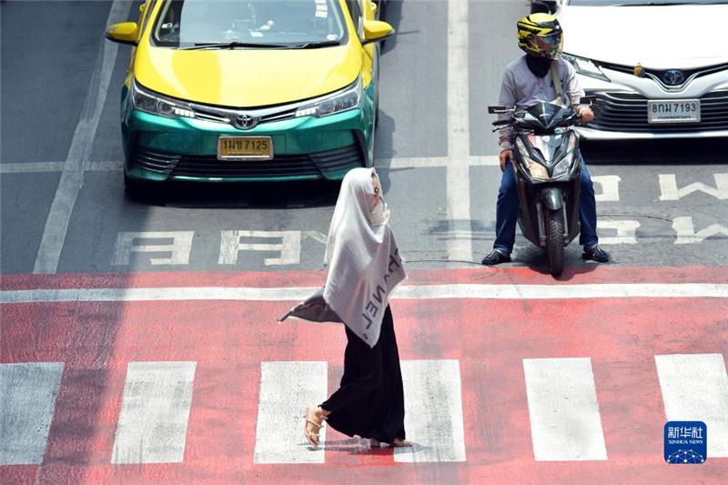 5月17日，行人在泰國(guó)曼谷街頭用圍巾遮陽(yáng)。新華社發(fā)（拉亨攝）