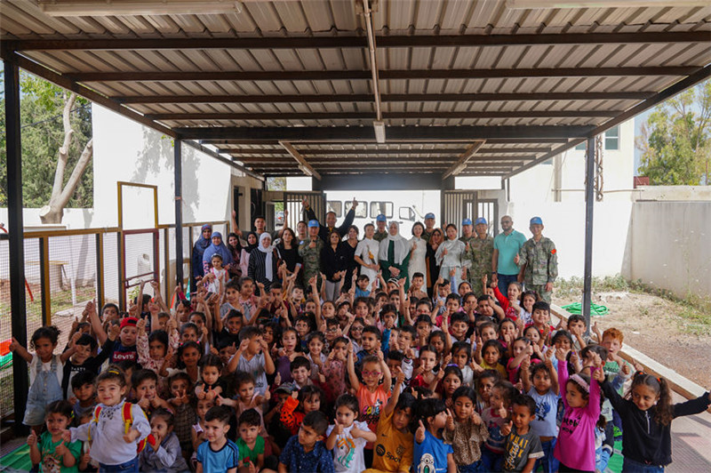 當?shù)貢r間5月30日，黎巴嫩南部庫雷拉公立小學，“六一”國際兒童節(jié)前夕，中國第21批赴黎維和多功能工兵分隊官兵看望慰問學校師生，并開展文化交流活動，圖為我維和官兵同師生合影。李竹林攝