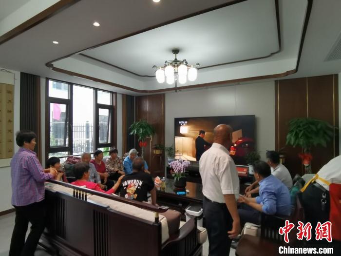 親友們集中在費(fèi)俊龍家中觀看返程的視頻。　鐘升 攝