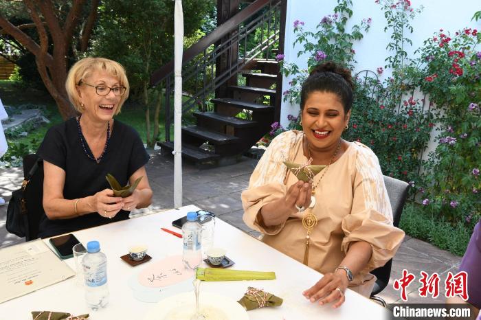 圖為嘉賓展示包粽子成果?！“亓种袊幕行墓﹫D。