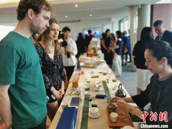 現(xiàn)場觀眾觀看中國展臺茶藝表演、了解茶文化。　靖樹 攝