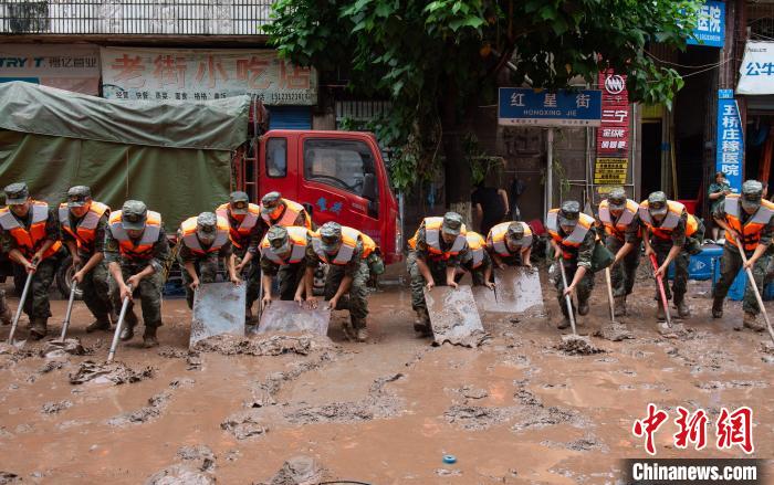7月4日，萬州區(qū)五橋街道，武警官兵清理街道上的淤泥。　冉孟軍 攝