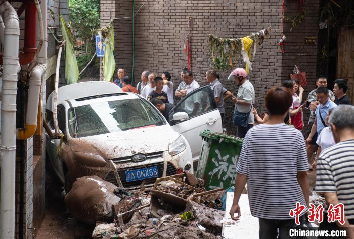 7月4日，萬州區(qū)五橋街道，居民救援受困的私家車?！∪矫宪?攝