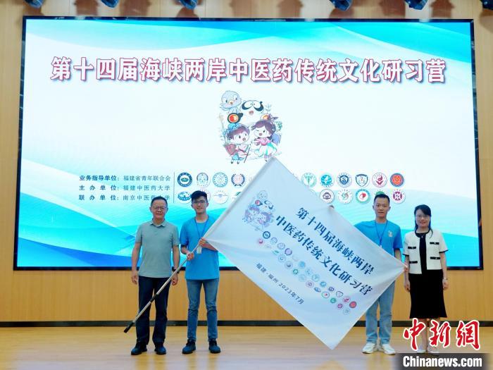 共青團(tuán)福建省委副書記吳雪(右一)、福建中醫(yī)藥大學(xué)黨委副書記林羽(左一)為兩岸學(xué)生代表頒授營(yíng)旗?！≡S燁婷 攝