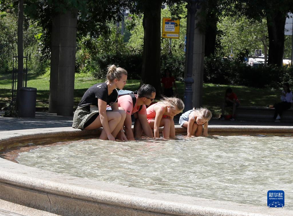 7月8日，人們在德國法蘭克福的一處噴泉玩水。近日，德國法蘭克福逐漸迎來暑熱天氣。新華社記者 張帆 攝