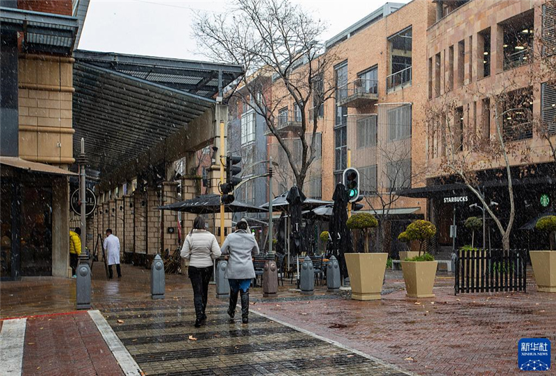 7月10日，在南非約翰內(nèi)斯堡一處商業(yè)區(qū)，人們在雪中行走。新華社記者 張譽(yù)東 攝