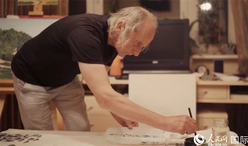 伊戈?duì)枴げ紶枛|諾夫在畫(huà)作上題詞。人民網(wǎng)記者 馬天翼攝