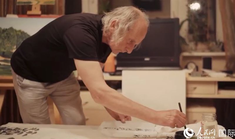 伊戈爾·布爾東諾夫在畫作上題詞。人民網(wǎng)記者 馬天翼攝