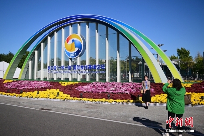 10月15日，北京，工作人員在國(guó)家會(huì)議中心外的第三屆“一帶一路”國(guó)際合作高峰論壇景觀(guān)布置前拍照留念。當(dāng)日，位于國(guó)家會(huì)議中心的第三屆“一帶一路”國(guó)際合作高峰論壇新聞中心啟動(dòng)試運(yùn)行。據(jù)悉，第三屆“一帶一路”國(guó)際合作高峰論壇將于10月17日至18日在北京舉行。<a target='_blank' href='/'><p  align=