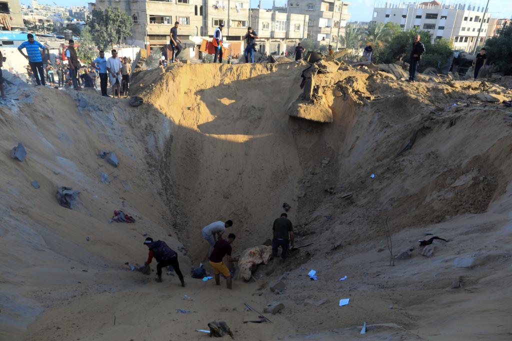 10月16日，在加沙地帶南部城市汗尤尼斯，人們?cè)谠庖陨幸u擊后的建筑廢墟中救援傷者。 新華社發(fā)（亞西爾·庫迪 攝）
