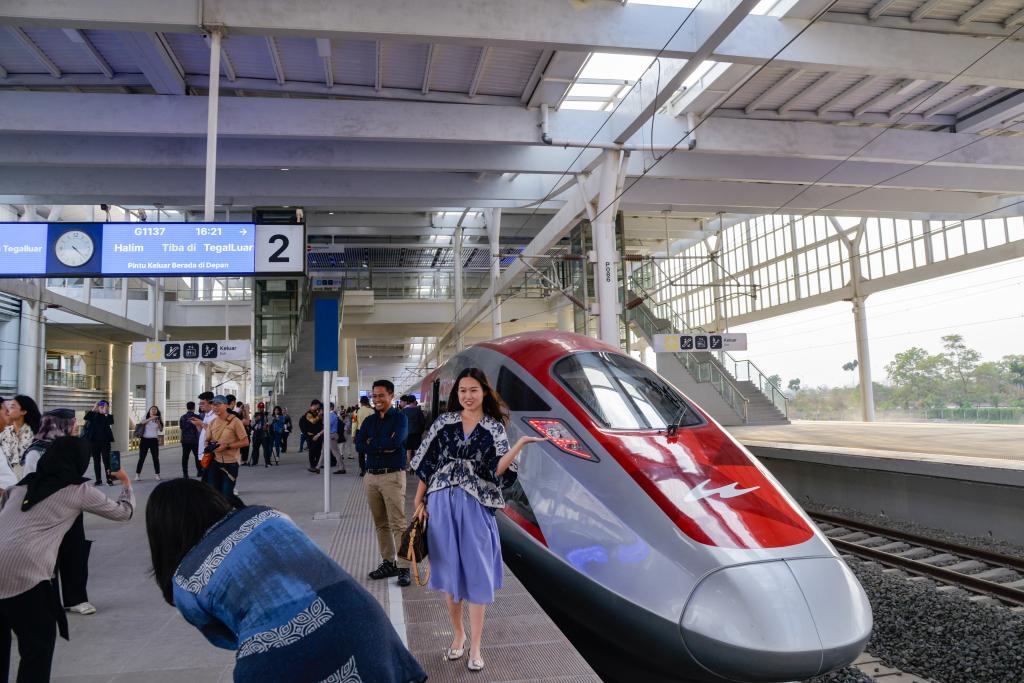 10月17日，在印度尼西亞萬隆德卡魯爾站，乘客在站臺上和雅萬高鐵高速動車組列車合影。