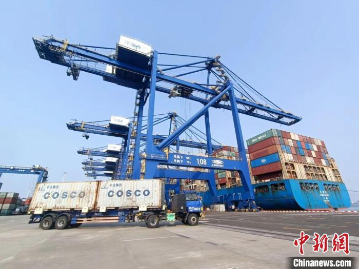 圖為海南洋浦國(guó)際集裝箱碼頭，卡車將集裝箱從后方堆場(chǎng)運(yùn)往碼頭裝卸區(qū)。　張?jiān)潞?攝
