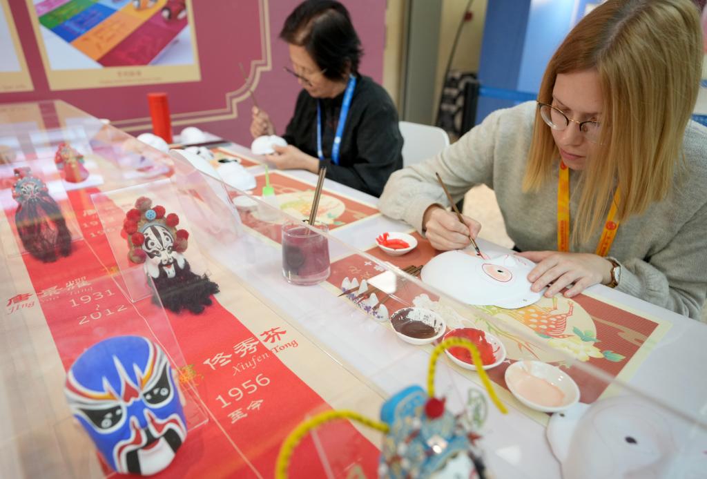 10月16日，在第三屆“一帶一路”國(guó)際合作高峰論壇新聞中心，來(lái)自比利時(shí)的記者（右）體驗(yàn)畫(huà)京劇臉譜。新華社記者 王毓國(guó) 攝