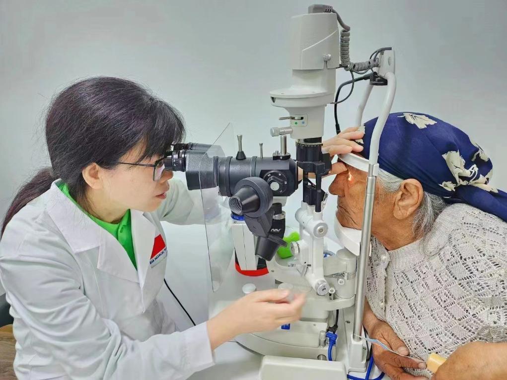北京大學(xué)人民醫(yī)院眼科醫(yī)生鮑永珍正在為中亞白內(nèi)障患者進(jìn)行眼部檢查。（北京大學(xué)人民醫(yī)院供圖）