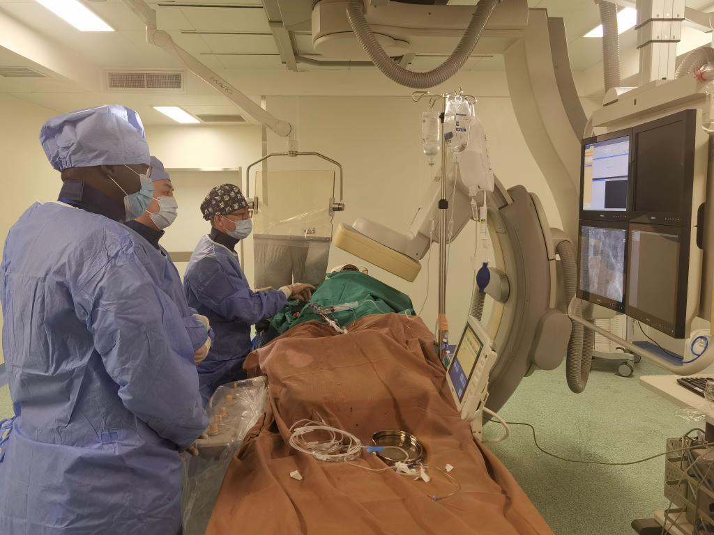 中國(guó)第29批援幾內(nèi)亞醫(yī)療隊(duì)隊(duì)員、首都醫(yī)科大學(xué)附屬北京天壇醫(yī)院心內(nèi)科副主任醫(yī)師王汝朋（右一）正在給患者做手術(shù)。（北京天壇醫(yī)院供圖）
