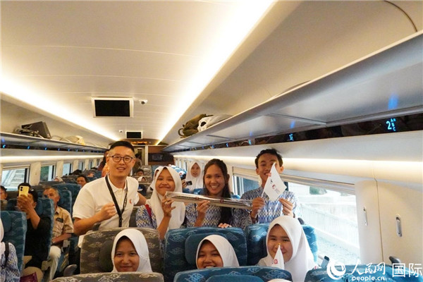 第一次乘坐雅萬高鐵動車組的學(xué)生們與動車組模型合影。人民網(wǎng)記者曹師韻攝