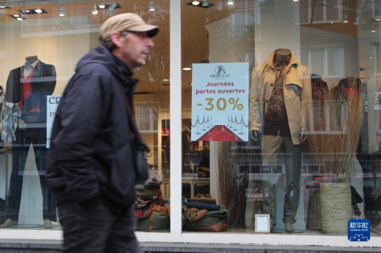   10月31日，一名男子從比利時(shí)布魯塞爾一家貼有打折信息的店鋪前走過。新華社記者 趙丁喆 攝