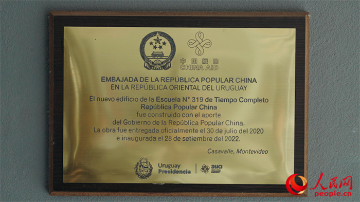 小學(xué)墻上懸掛的中國援助標識。人民網(wǎng)記者 張若涵攝
