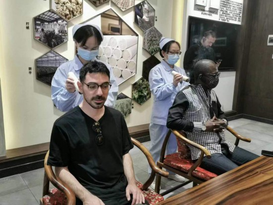 2023“一帶一路”媒體合作論壇聯(lián)合采訪團團員在九牛草展示館體驗艾灸。（本報記者 黃超攝）