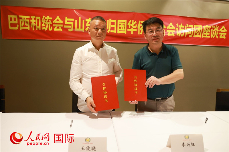 中國(guó)僑聯(lián)副主席、山東省僑聯(lián)主席李興鈺（右）與巴西和統(tǒng)會(huì)會(huì)長(zhǎng)王俊曉簽署合作協(xié)議書。人民網(wǎng)記者 陳海琪攝