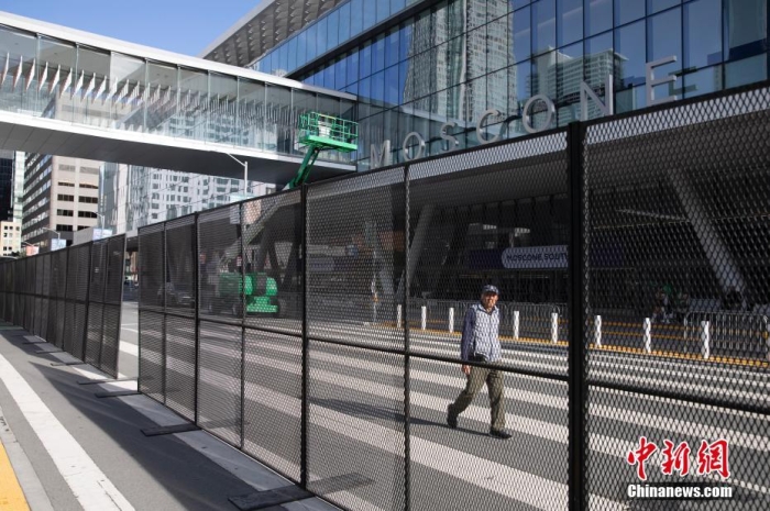 當(dāng)?shù)貢r間11月10日，一名行人從美國舊金山莫斯康中心周圍的金屬圍欄旁經(jīng)過。隨著亞太經(jīng)合組織(APEC)第三十次領(lǐng)導(dǎo)人非正式會議臨近，作為會議場地的莫斯康中心附近出現(xiàn)金屬圍欄，執(zhí)勤警察也大幅增加。<a target='_blank' href='/'><p  align=
