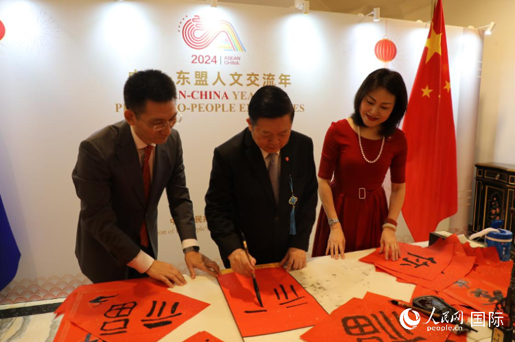 東盟秘書長高金洪（中）在活動現(xiàn)場寫福字。人民網(wǎng)記者曹師韻攝
