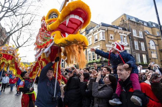 2月11日，人們在英國倫敦的新春巡游活動中觀看舞龍表演。新華社發(fā)（史蒂芬·程攝）
