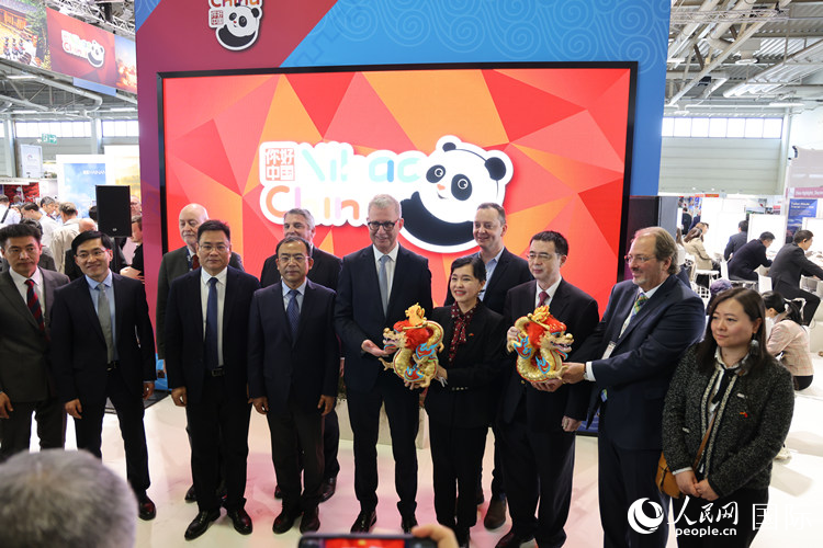 參加中國(guó)館開幕式的嘉賓們?cè)凇澳愫?中國(guó)” 展臺(tái)前合影留念。