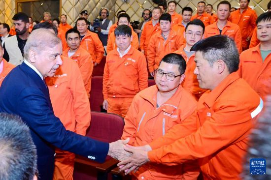 4月1日，在巴基斯坦西北部開伯爾-普什圖省達蘇，巴基斯坦總理夏巴茲（左）同達蘇水電站項目中方員工握手。新華社發(fā)（巴基斯坦新聞與廣播部下轄媒體信息部門供圖）