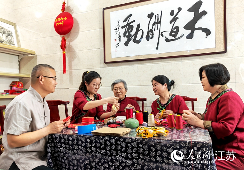 王秀英老人指導(dǎo)孫女制作香包。人民網(wǎng) 閆峰攝