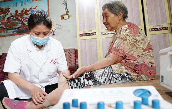 護理團隊醫(yī)生為老人進行低頻功能康復(fù)。陳佳兵攝