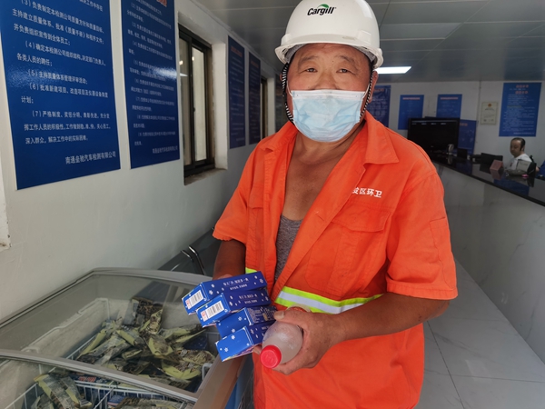 1環(huán)衛(wèi)工倪建宏小憩后，為還同事帶去冷飲。人民網(wǎng)記者王繼亮攝