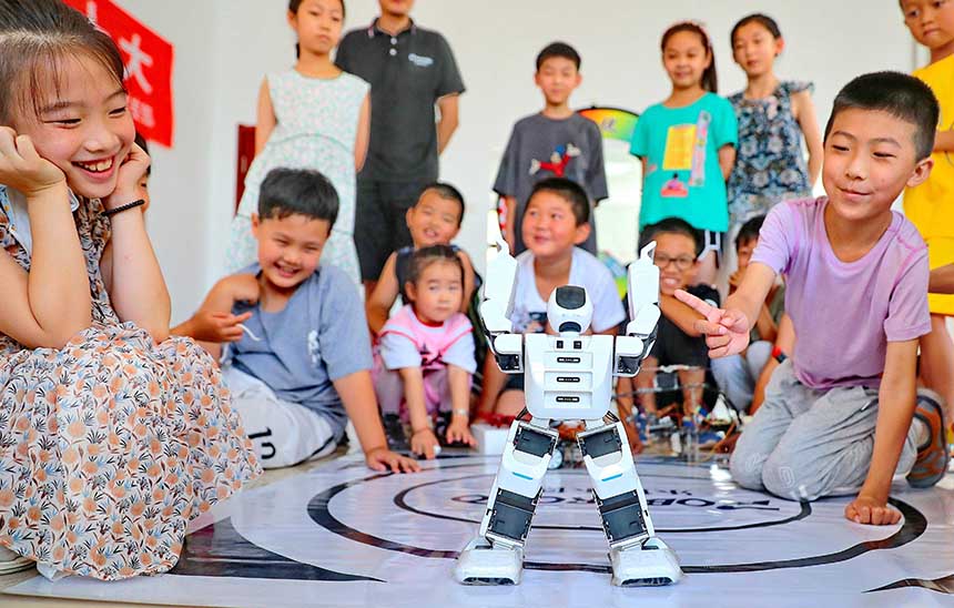 2022年7月19日，河北省秦皇島市海港區(qū)白塔嶺街道秦皇半島第二社區(qū)內(nèi)，小朋友正在觀看“機(jī)器人跳舞”。 曹建雄攝