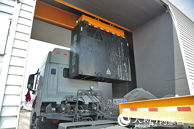 萬利新能源數(shù)字陸港里，正在充換電站進行換電的重卡。人民網(wǎng)記者 趙夢月攝