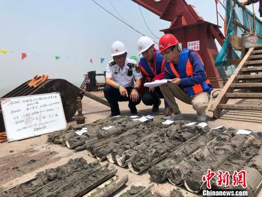 圖為勘察設(shè)計(jì)人員與海事局工作人員查看巖芯情況?！∥赫?攝