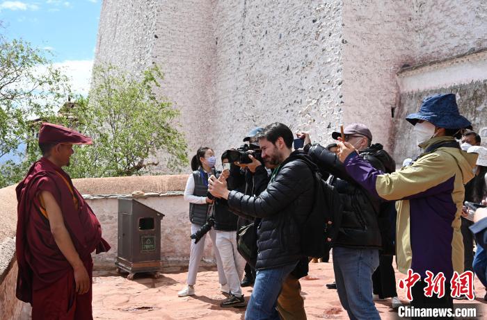 圖為中外媒體拍攝朝拜布達拉宮的僧人?！≮w朗 攝