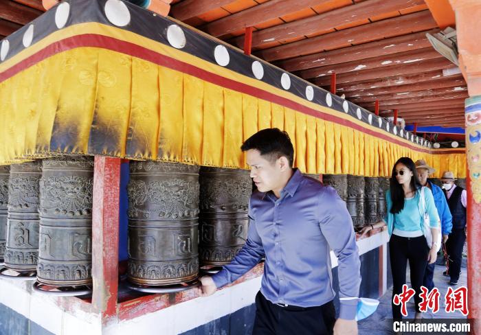 圖為外籍嘉賓體驗藏族傳統(tǒng)轉(zhuǎn)經(jīng)筒。　馬銘言 攝