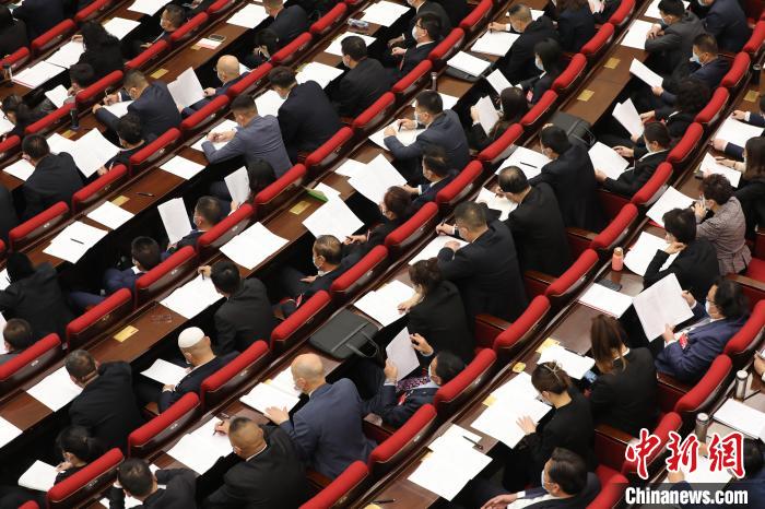 圖為會議現(xiàn)場，參會代表正在聽取政府工作報告?！∑钤鲚?攝