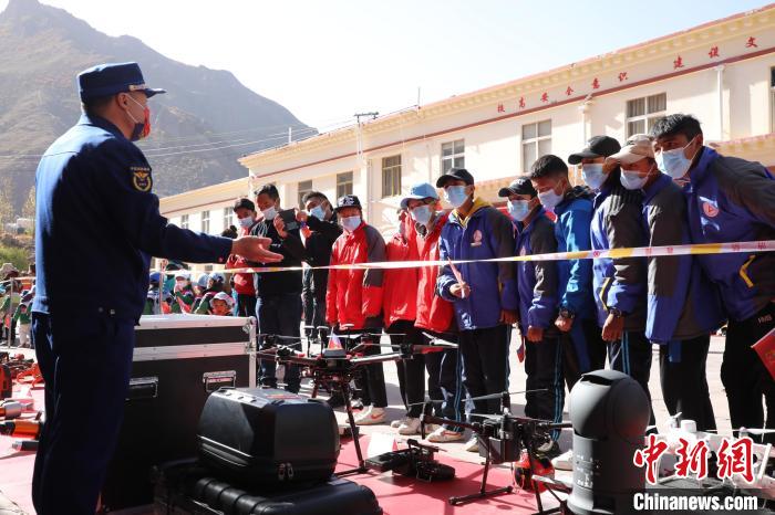 圖為消防指戰(zhàn)員為學(xué)生講解、演示先進(jìn)救援裝備?！≮w琳 攝