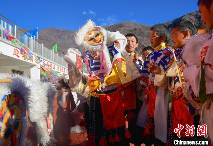 圖為加查縣安繞鎮(zhèn)小學(xué)學(xué)生在試穿藏戲面具?！∝暩聛?lái)松 攝