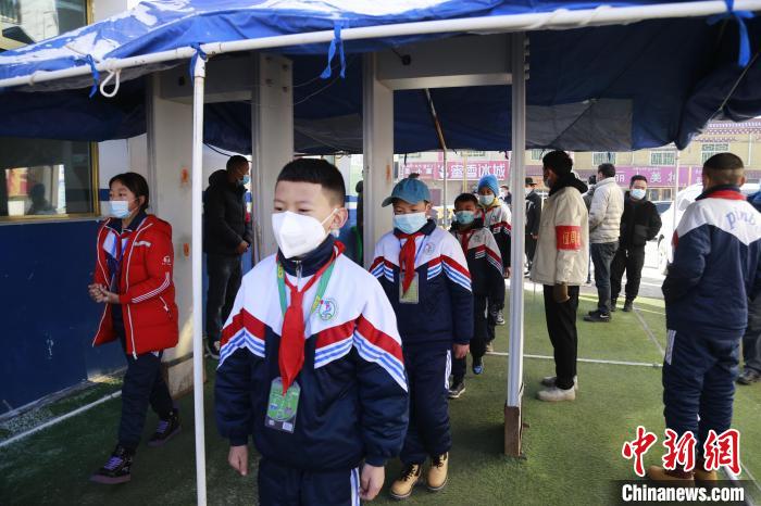 圖為學(xué)生測量體溫后進入校園?！●R銘言 攝