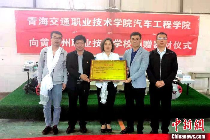 圖為李富香(中)代表學(xué)校為州縣技校捐贈器材。(資料圖) 青海省教育廳供圖