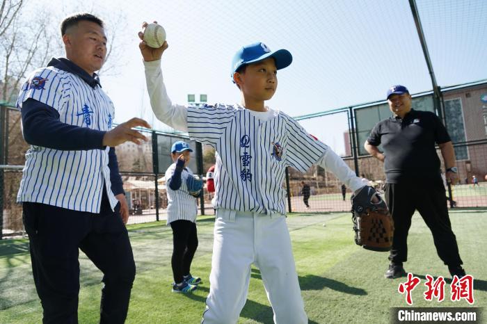 圖為教練指導(dǎo)小棒球手?jǐn)S球技術(shù)。　馬銘言 攝